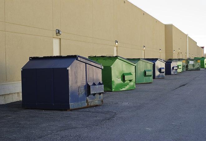 a construction worker unloading debris into a blue dumpster in Double Oak, TX